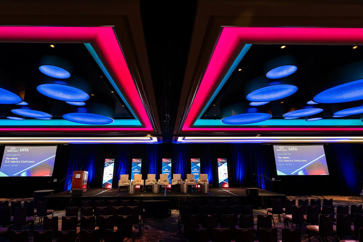 Conference main stage with panel seating, screens and branded signage