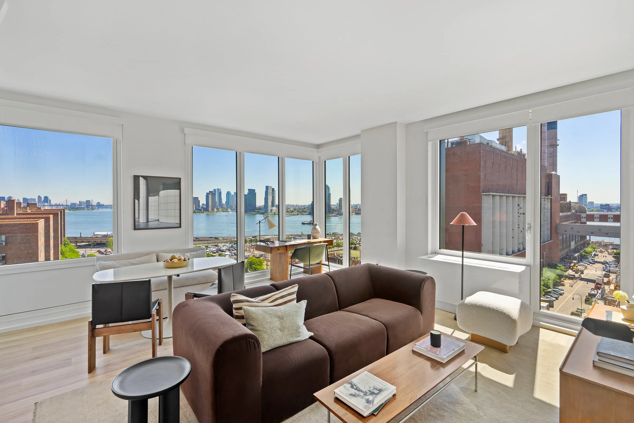 Corner living room at 644 East 14th Street with East River views, staged model residence