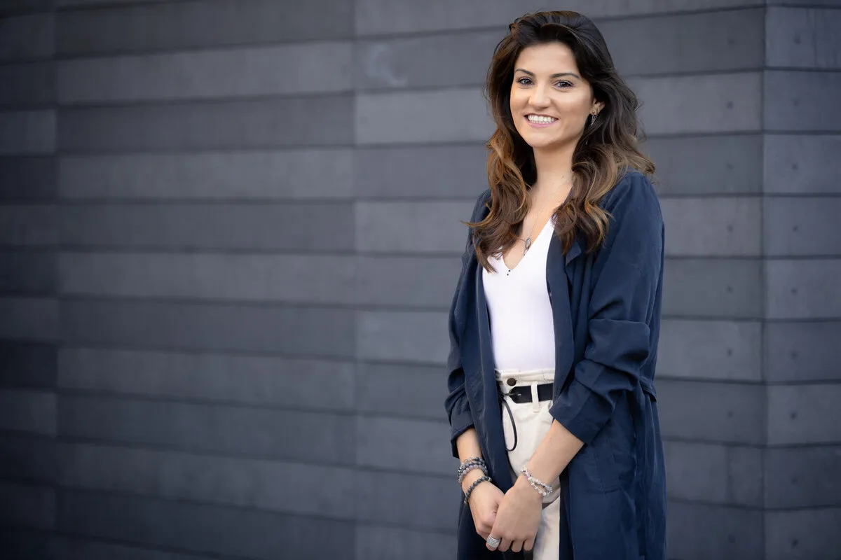 Professional headshot of a woman against a slate wall